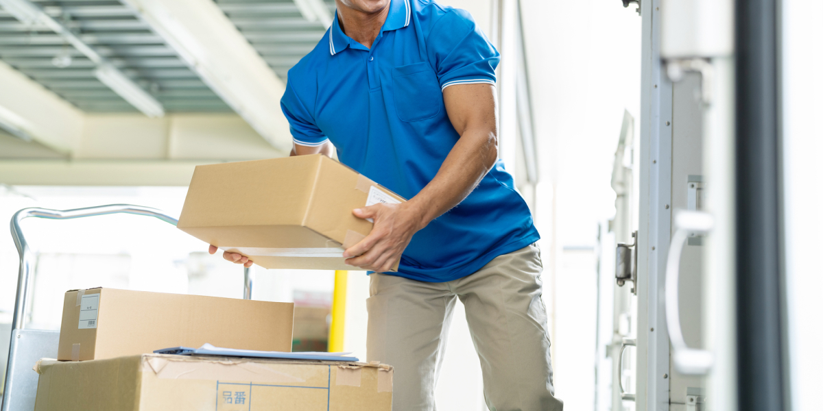 荷物をトラックに載せる男性の手元